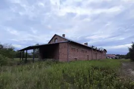 Opuszczony, podłużny dom z czerwonej cegły