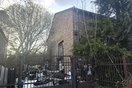 ceglany dom z śmieciami na ogórdku