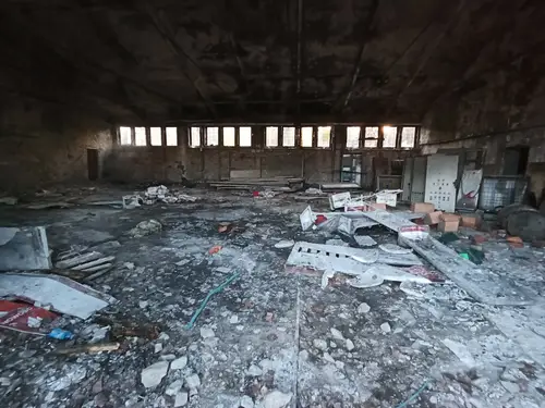 Opuszczony plac z budynkami w zielonce - zdjęcie 1/8