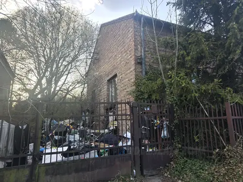 ceglany dom z śmieciami na ogórdku - zdjęcie 1/1