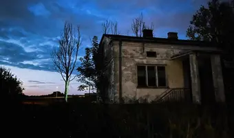 Dom z kapliczką u rozwalonymi budynkami
