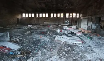 Opuszczony plac z budynkami w zielonce