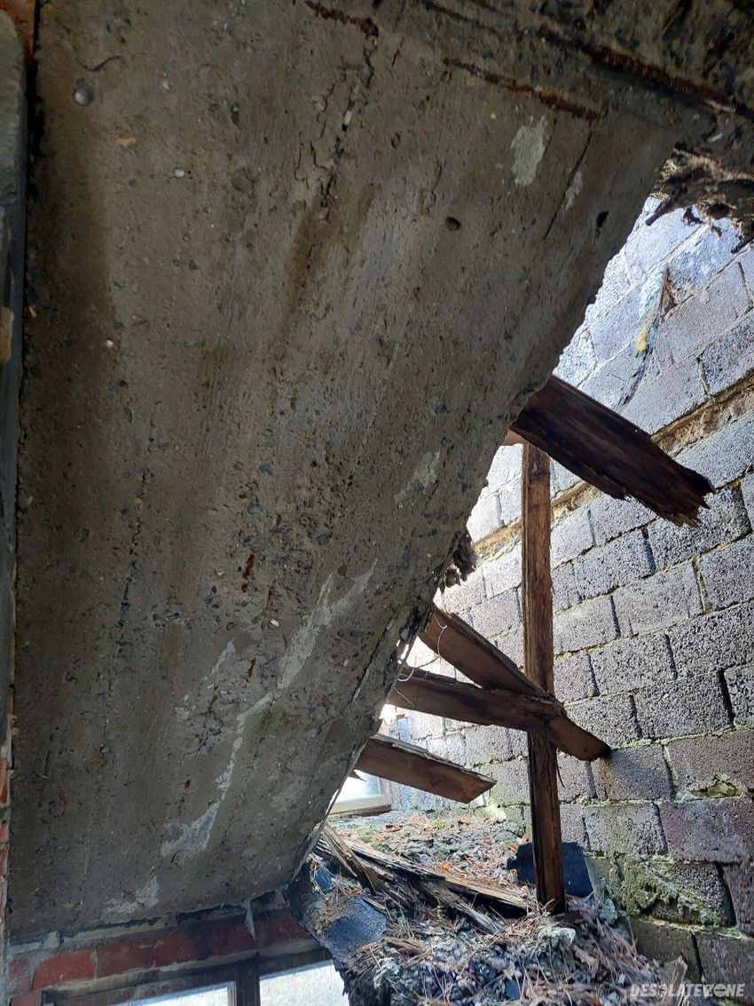 Opuszczony modernistyczny dom z częściowo zawalonym dachem