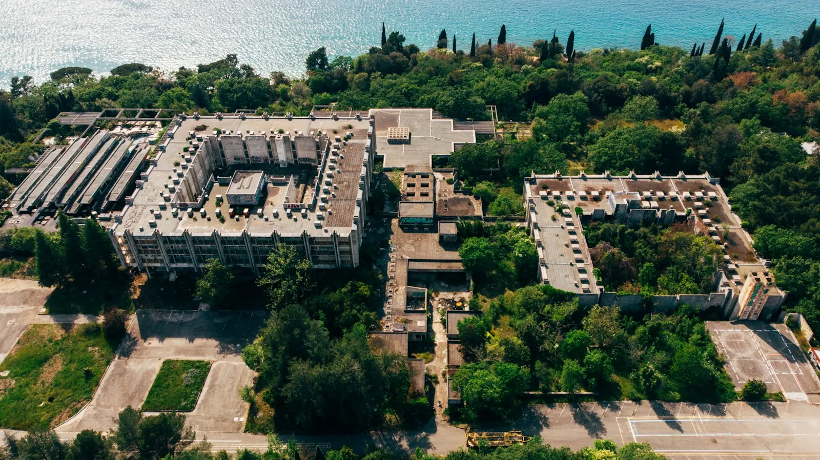 Widok z drona na opuszczony kompleks hotelowy zarośnięty drzewami